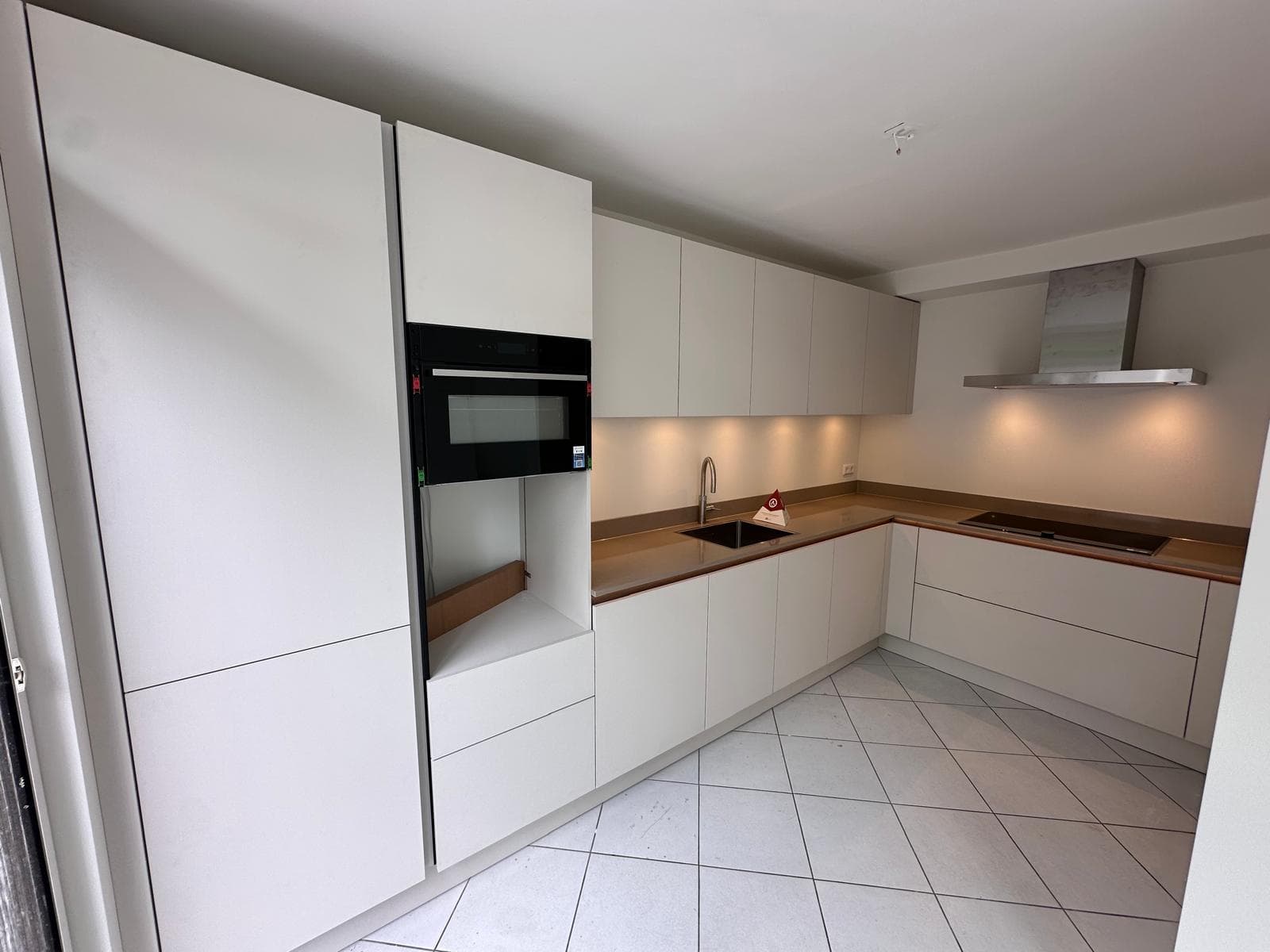 Crèmekleurige keuken met marmeren blad en bronzen accenten