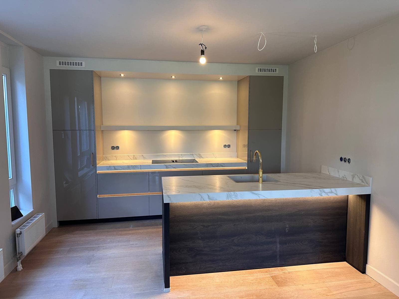 Grijze keuken met gouden grepen en kraan