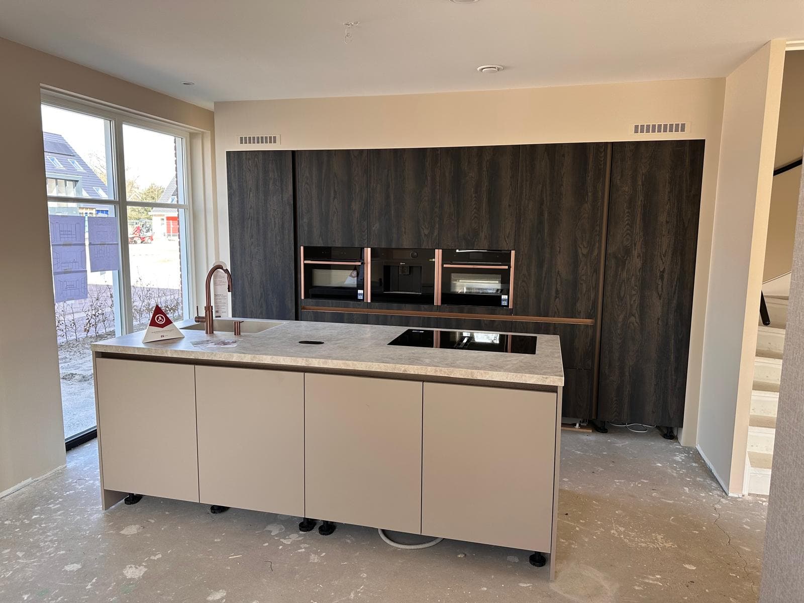 Donkere houtlook keuken met koperen kraan op marmeren werkblad
